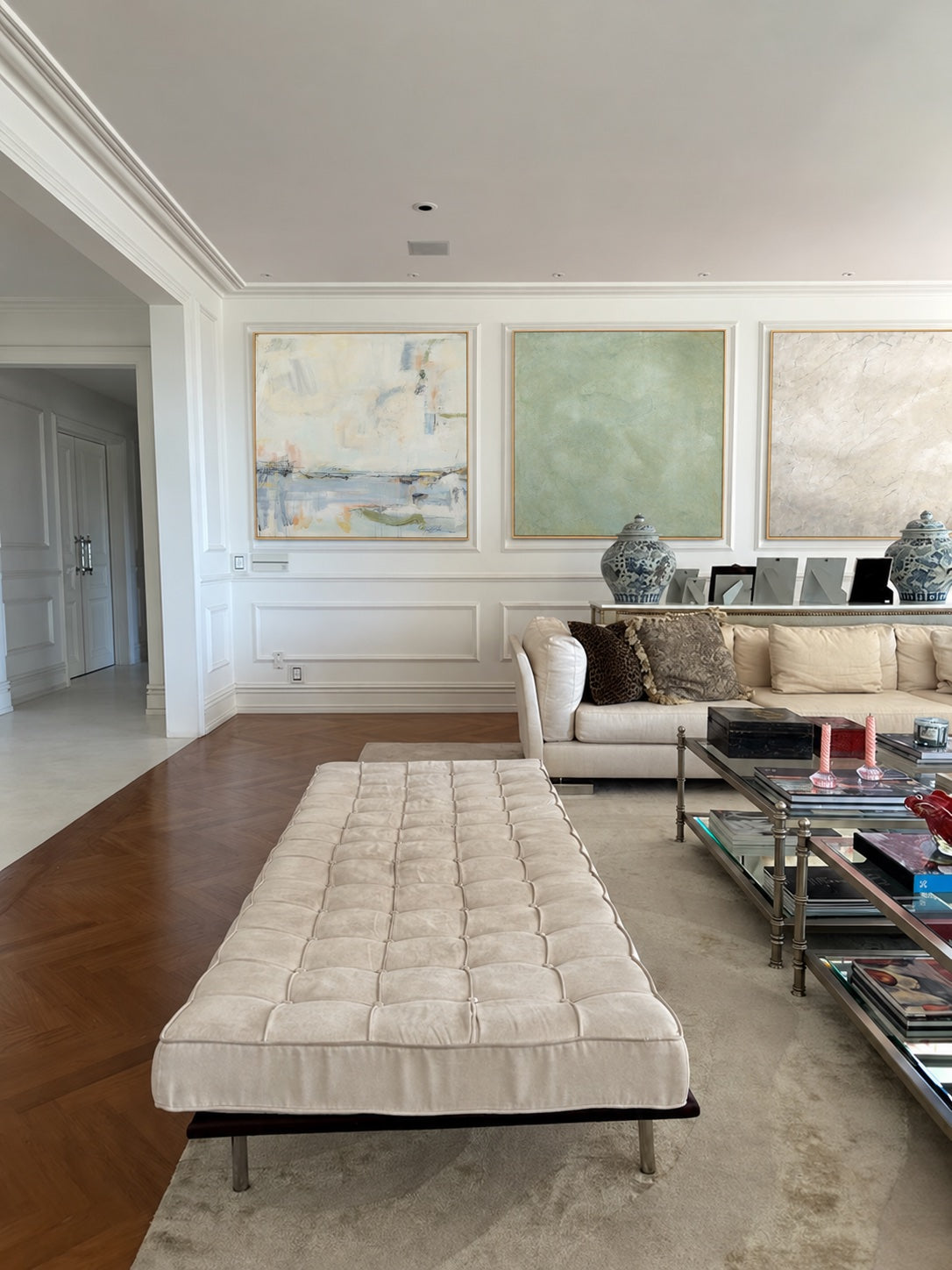 Blue Blush, Moss and Neutral Square arranged above a cream sofa