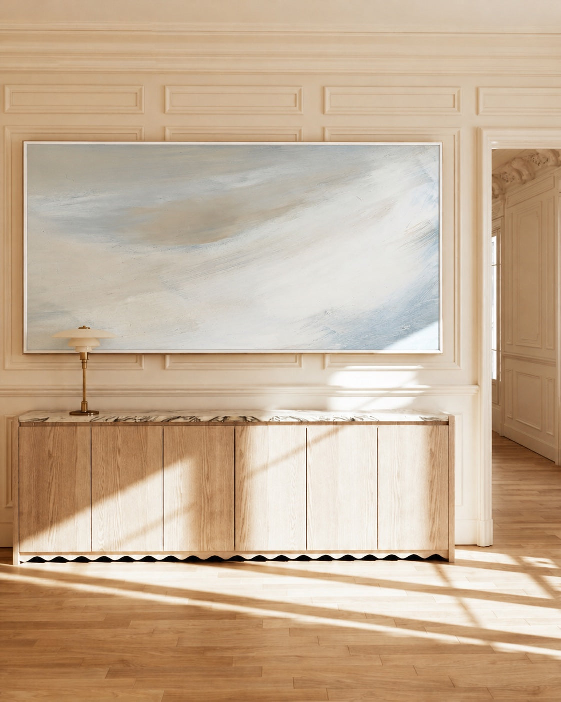 Serene Skies II above a wooden sideboard in afternoon sunlight